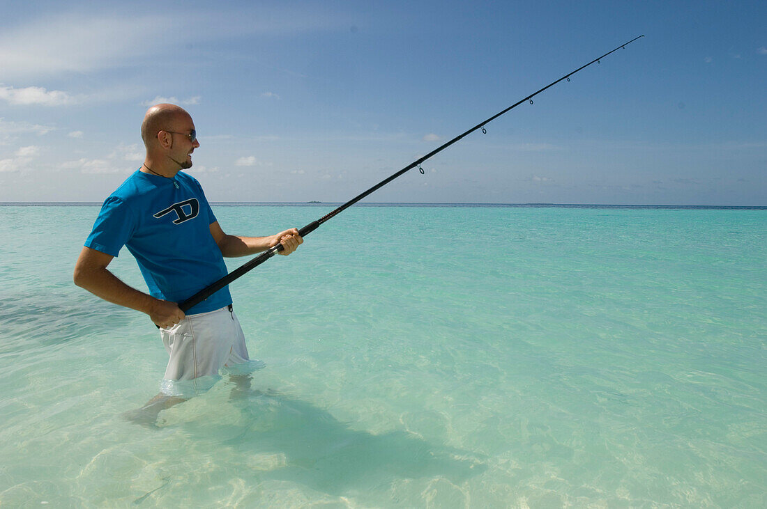 Mann beim Fischen in der Lagune, Luxusurlaub auf eine Privatinsel mit eigener Yacht, Rania Experience, Faafu Atoll, Malediven