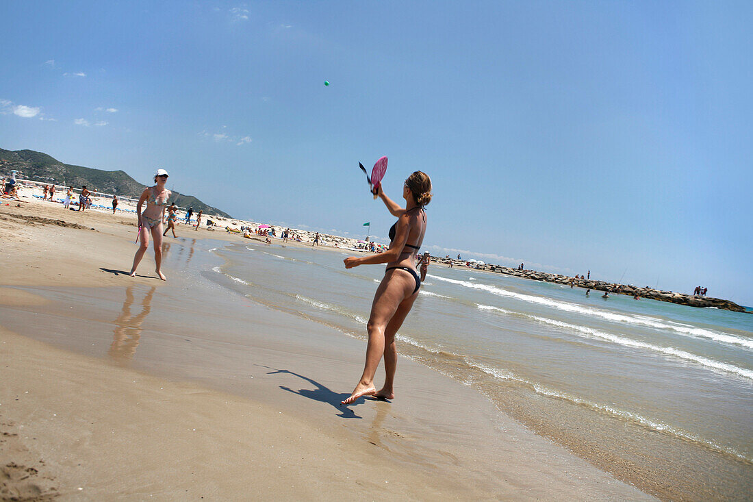 Women playing on beach, Sitges, Catalonia, Spain