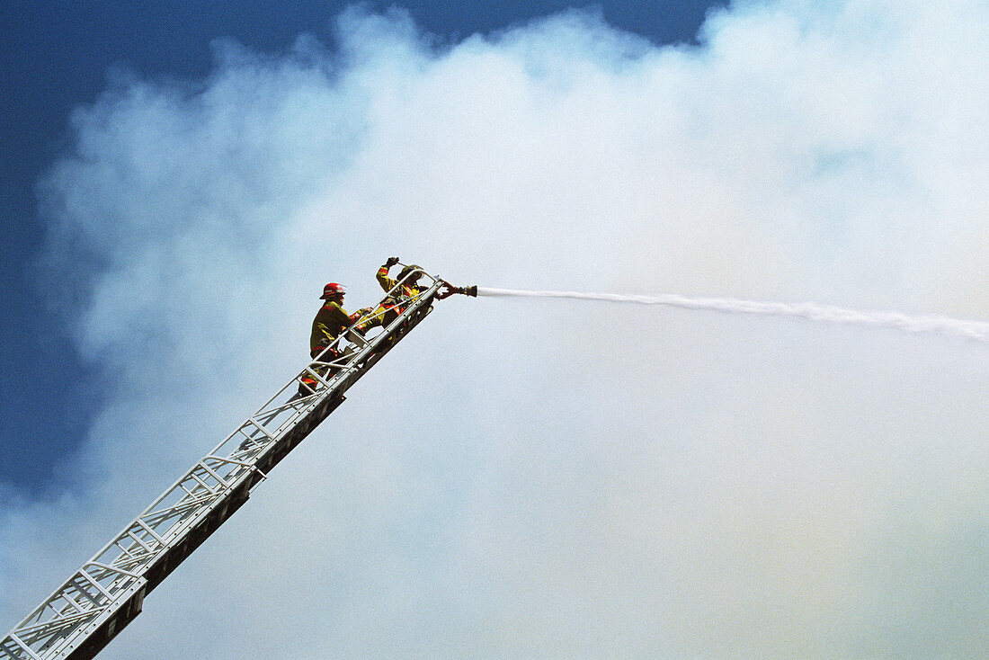 Firemen using water cannon at scene of fire