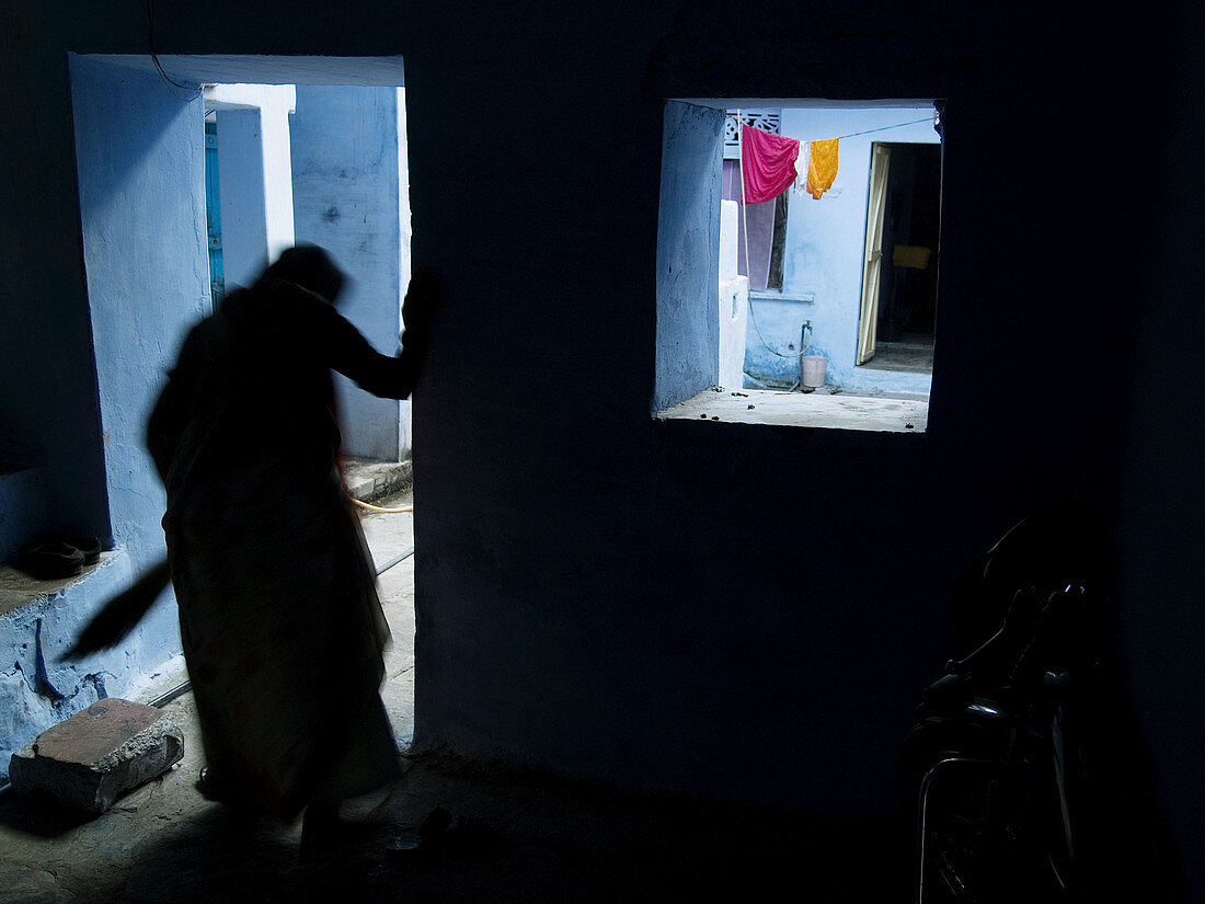 Woman walks in doorway of house, Bundi, Rajasthan, India