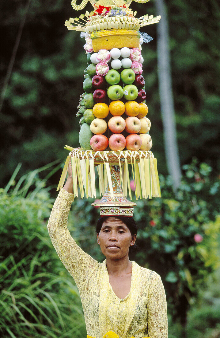 Woman carrying offers to temple during the Galungan Festival. Bali, Indonesia