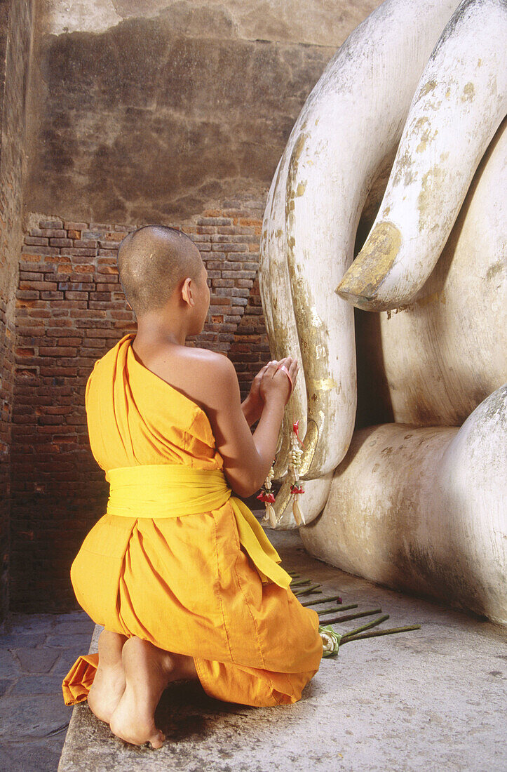 Novice monk Praying Buddha at temple Wat Si Chum. Sukhothai. Thailand