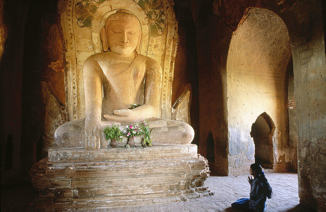 Bagan s girl meditating in front of a buddha s statue. Bagan. Myanmar (Burma)