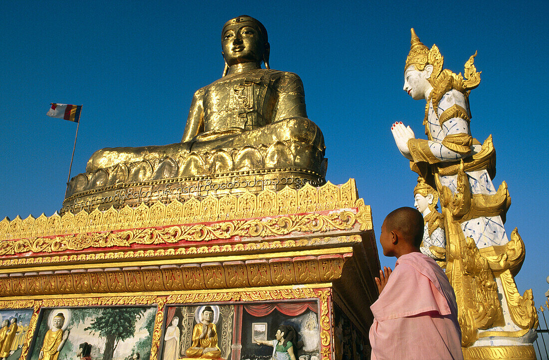 Buddhist nuns praying to Giant Buddha. Sagaing. Mandalay. Myanmar (Burma).