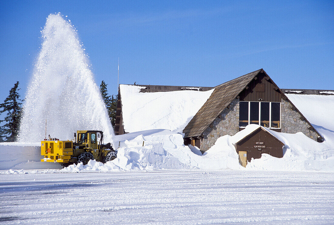 Snow plow blowing snow from the parking lot at Crater Lake. Crater Lake National Park. Oregon. USA