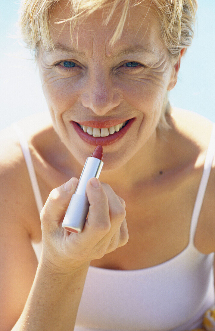 Woman applying lipstick