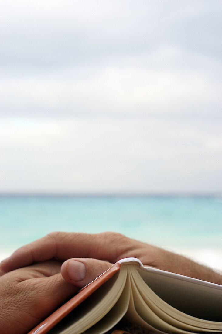 Adult, Adults, Beach, Beach chair, Beach chairs, Beaches, Book, Books, Calm, Calmness, Chill out, Chilling out, Close up, Close-up, Closeup, Color, Colour, Contemporary, Daytime, Deck chair, Deckchair, Exterior, Hand, Hands, Holiday, Holidays, Human, Leis