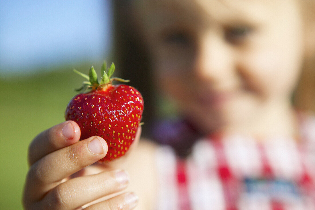 Girl holding strawberry