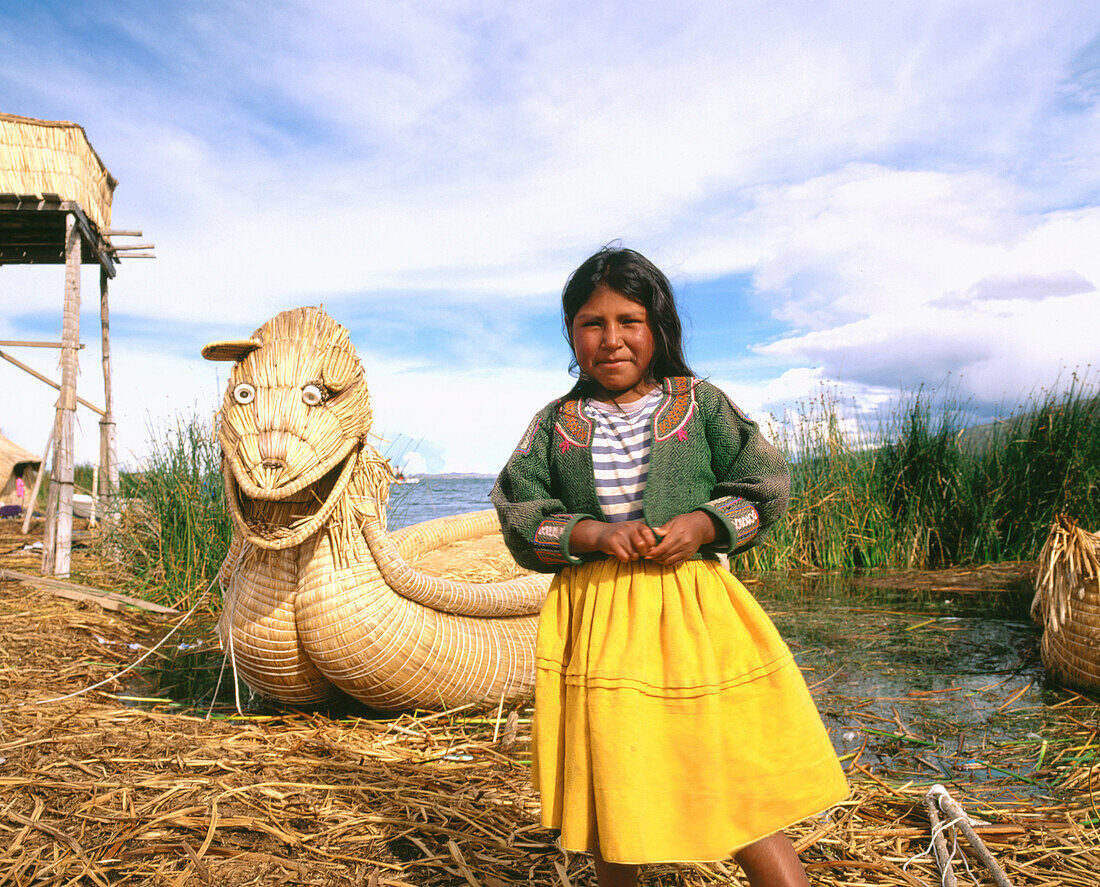 Uru indian girl and totora reeds boat. Titicaca Lake. Peru