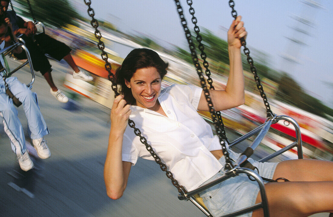 Woman on wave swinger carousel in amusement park. Florida. USA