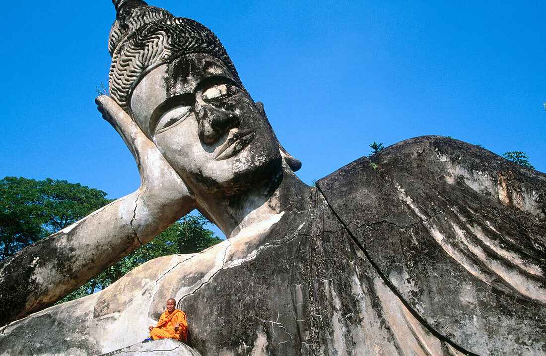 Monk at the giant Buddha, Buddha Park. Vientiane. Laos