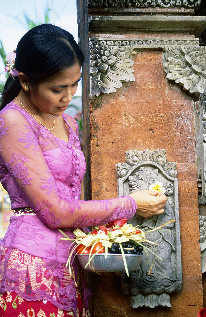 Balinese woman making offerings to gods. Ubud, Indonesia