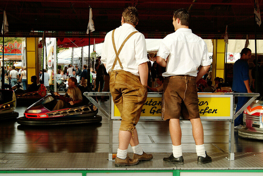 Young Bavarians watching bumper cars at fair. Regensburg. Bavaria, Germany