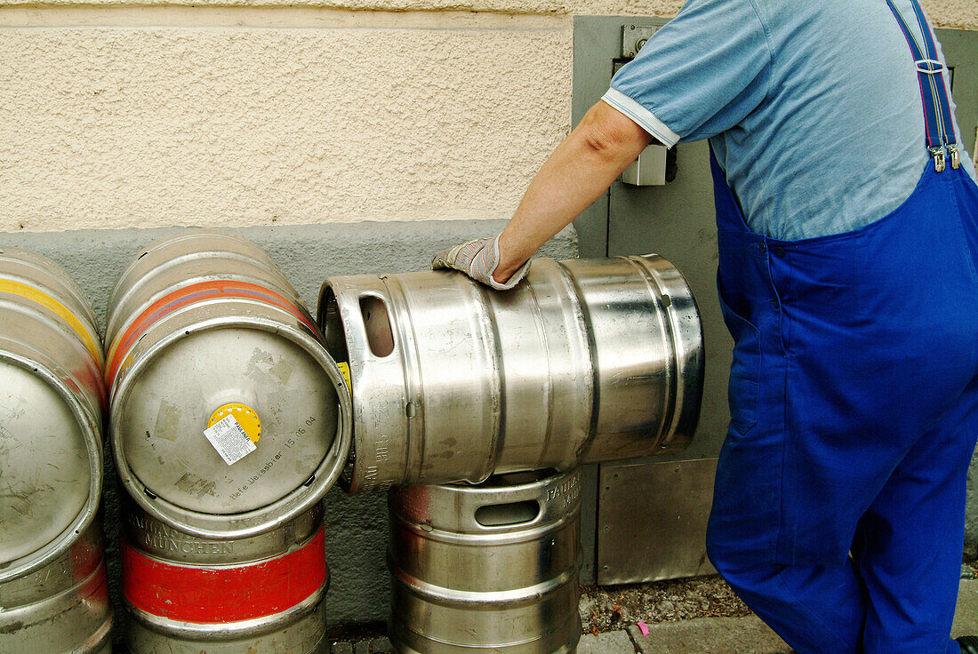 Worker transporting beer barrels to restaurant. Munich, Germany