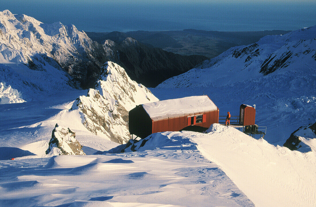 Skier and centennial hut at Franz Josef Glacier. Westland NP. South Island. New Zealand