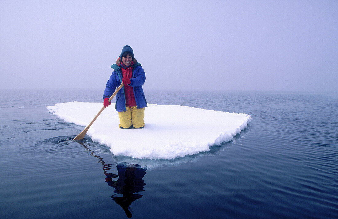 Woman paddling an icefloe near Petermann Island. Antarctica