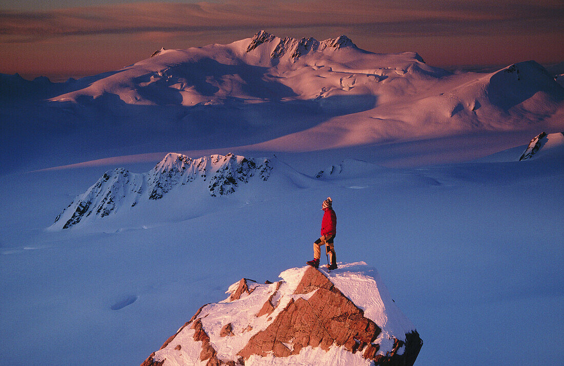 Climber on summit at sunset above Franz Josef Glacier. Westland National Park. New Zealand