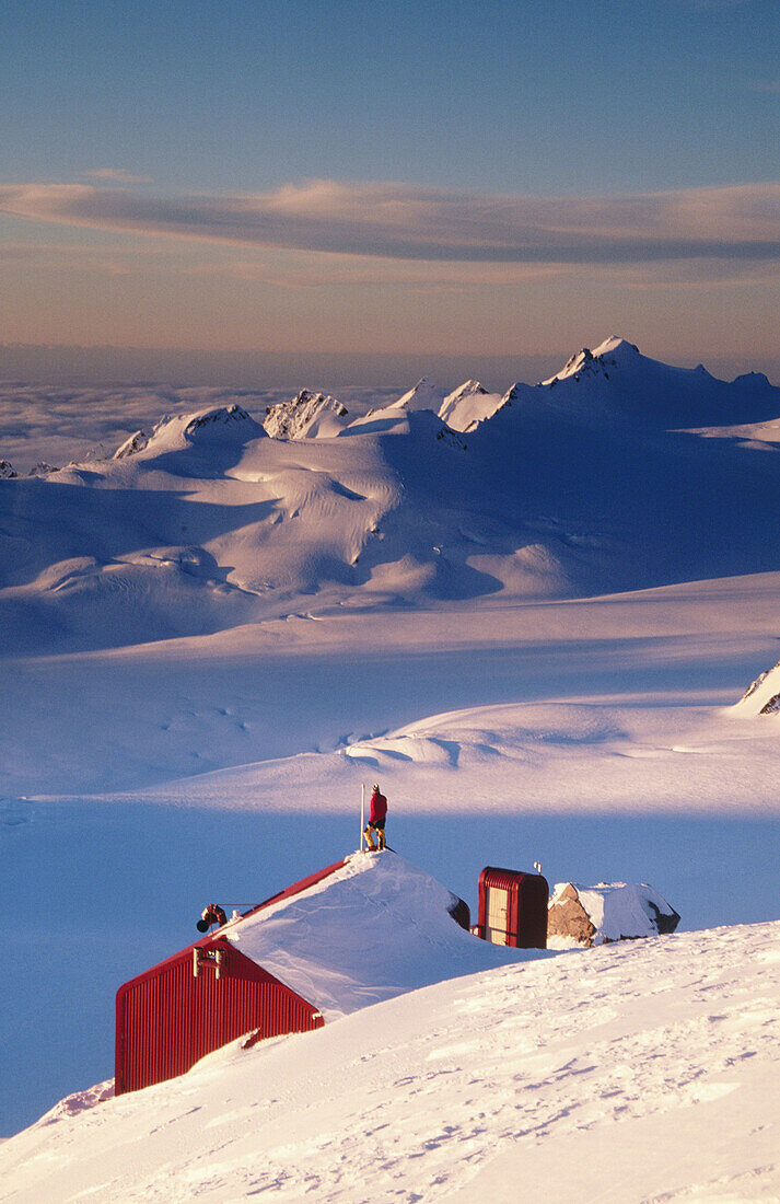 Climber on centennial hut roof. Franz Josef Glacier. Westland National Park. New Zealand