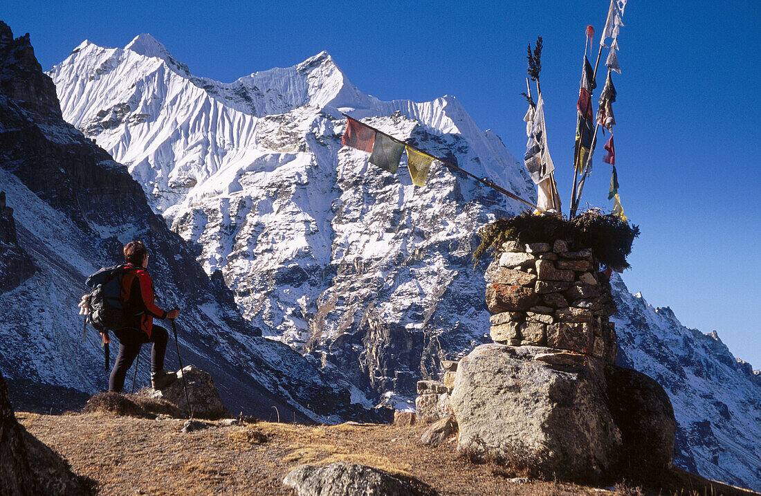 Trekker beside chorten, under Mera Peak (6461m). Lhonak. Kangchenjunga. East Nepal