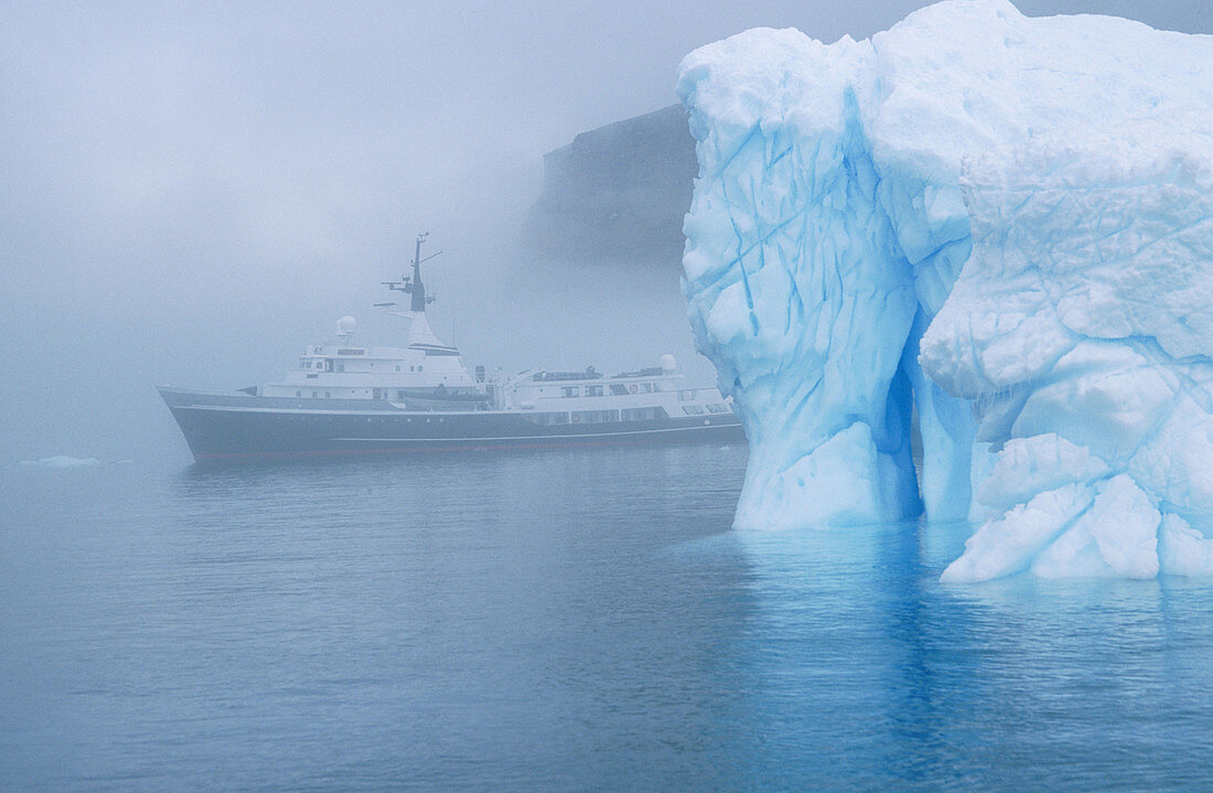 Ship in fog and iceberg off Brown Bluff. Antarctic Peninsula. Antarctica