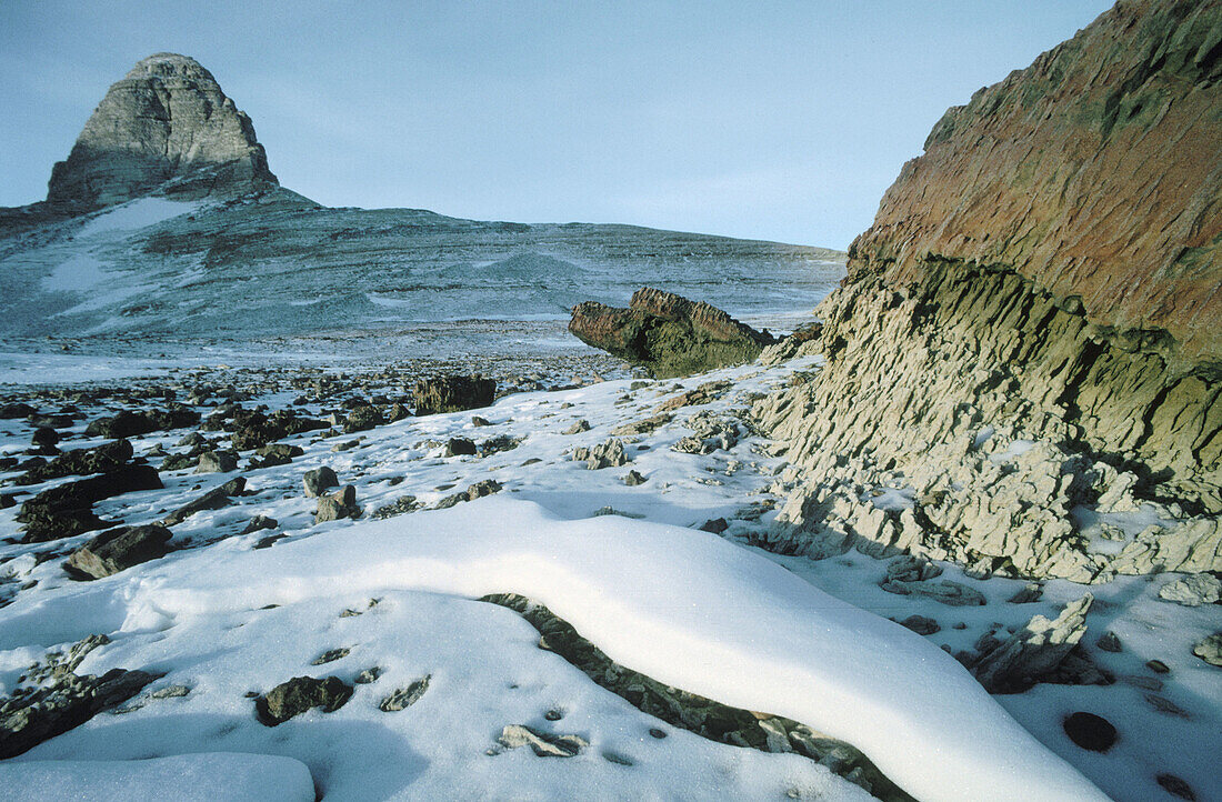 Snowdrift and sandstone, dry valley rock spire behind Mt. Dido. Olympus range, Antarctica