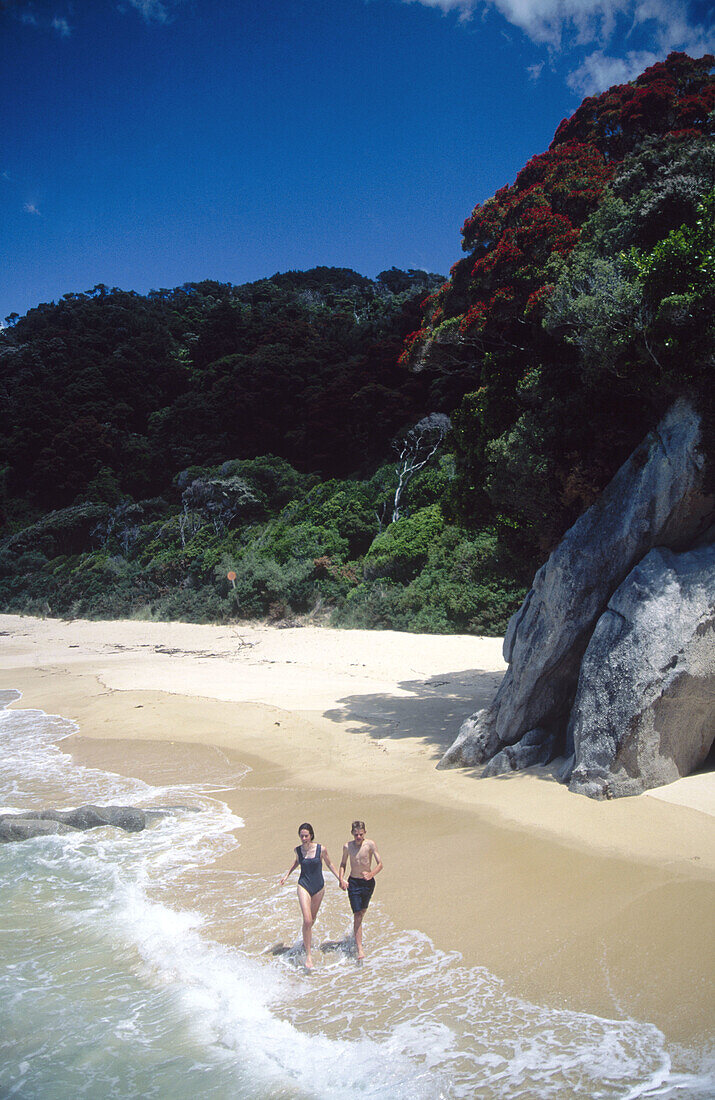 Kids running along beach. Abel Tasman National Park. New Zealand.