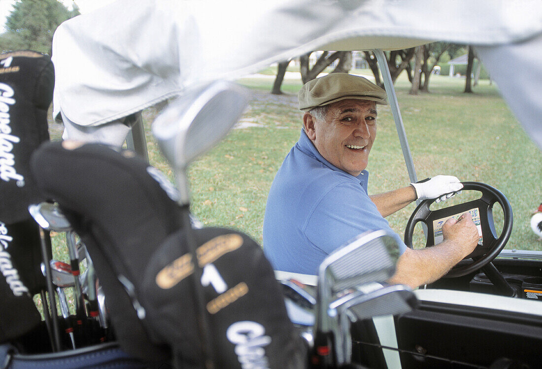 Mature man riding a golf cart