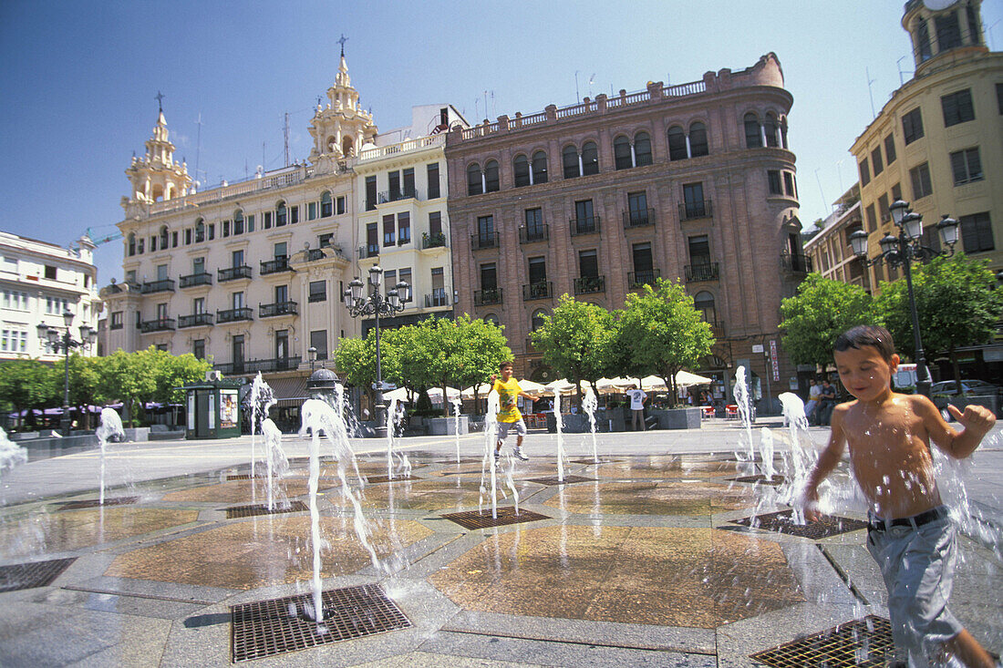 Boy playing with fountain water. Córdoba. Spain