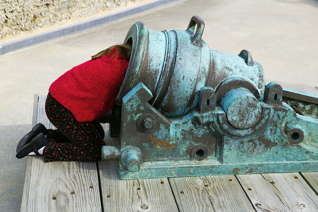 Girl with head inside antique cannon. The Castillo de San Marcos in Saint Augustine, Florida. Called Fort Marion at this time