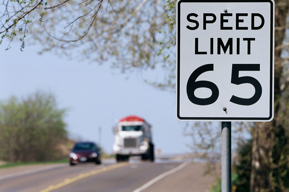 Speed limit sign, auto and truck.
