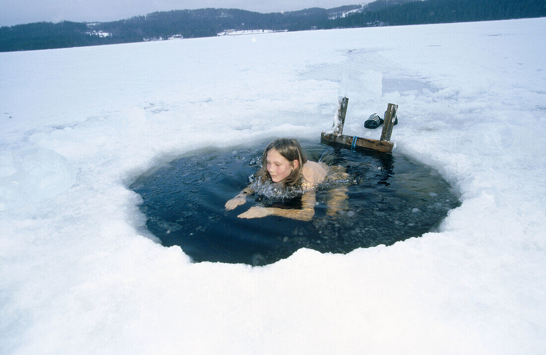 Hole in the ice, having a cold bath after the sauna. Jämtland, Sweden