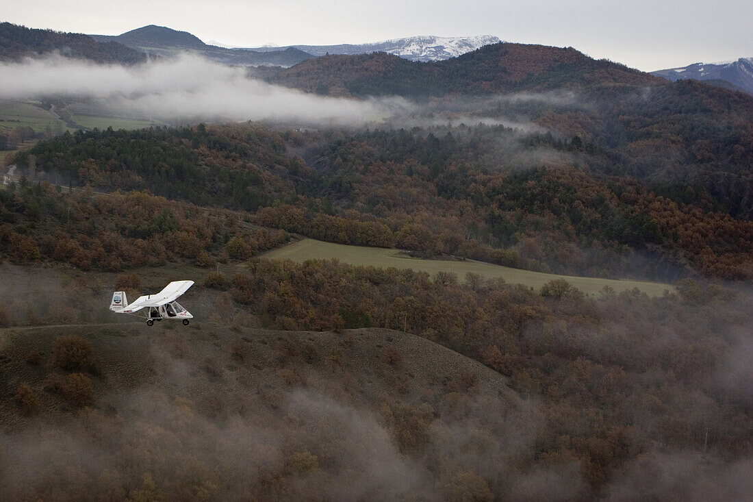 Luftaufnahme eines ULM Flugzeugs über den Bergen, Südfrankreich, Frankreich, Europa