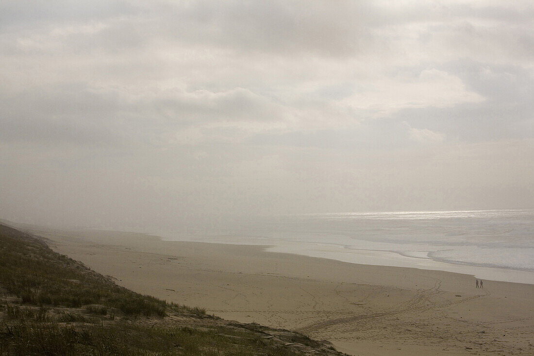 Paar geht im Winter am Strand spazieren, Bassin d’Arcachon, Lacarnau, Gironde, Frankreich