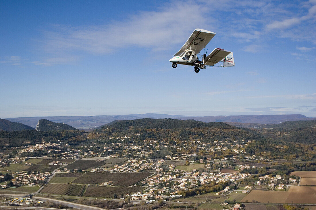 Luftaufnahme eines ULM Flugzeugs über dem Dorf Villeneuve, Südfrankreich, Frankreich, Europa