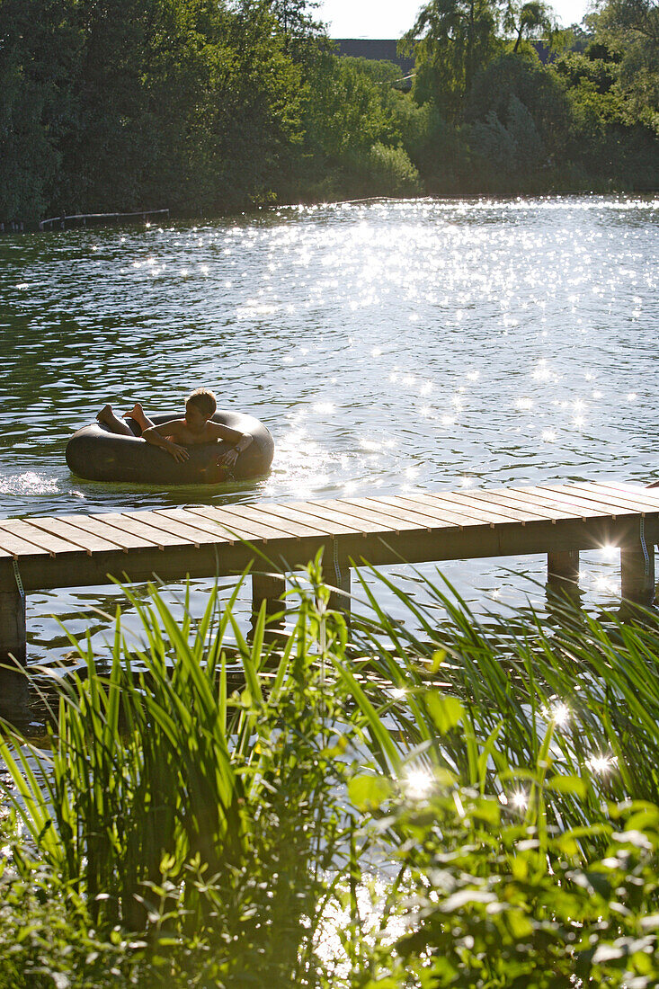 Boy bathing at Wesslinger Lake on a summer's day, Bavaria, Germany