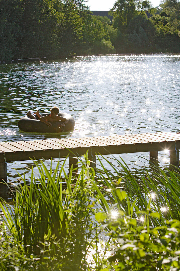 Junge badet an einem Sommertag im Wesslinger See, Bayern, Deutschland