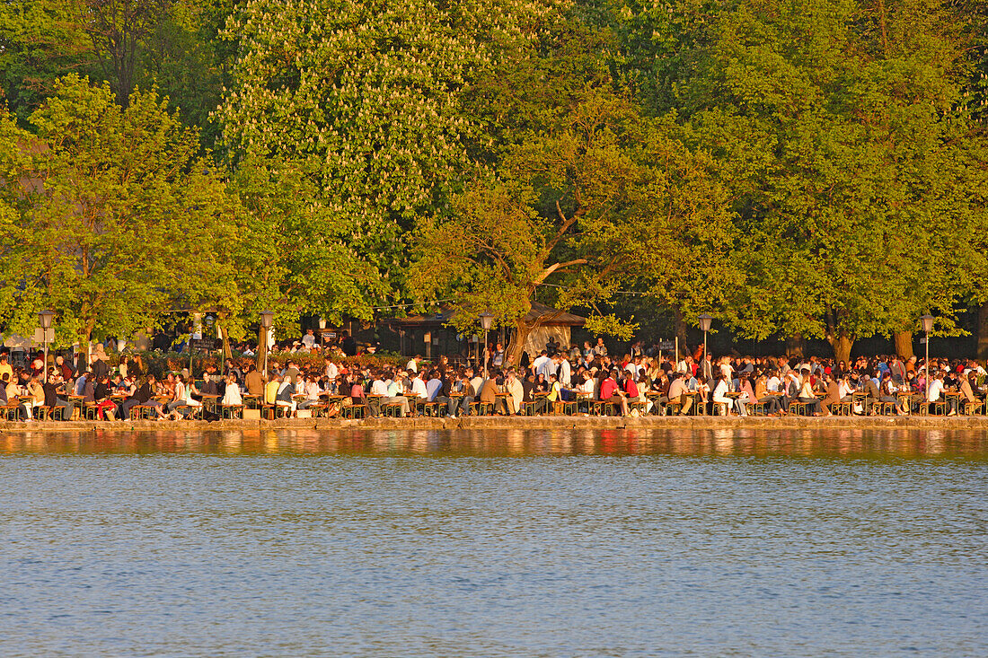 Menschen sitzen im Biergarten Seehaus am Kleinhesseloher See, Englischer Garten, München, Bayern, Deutschland