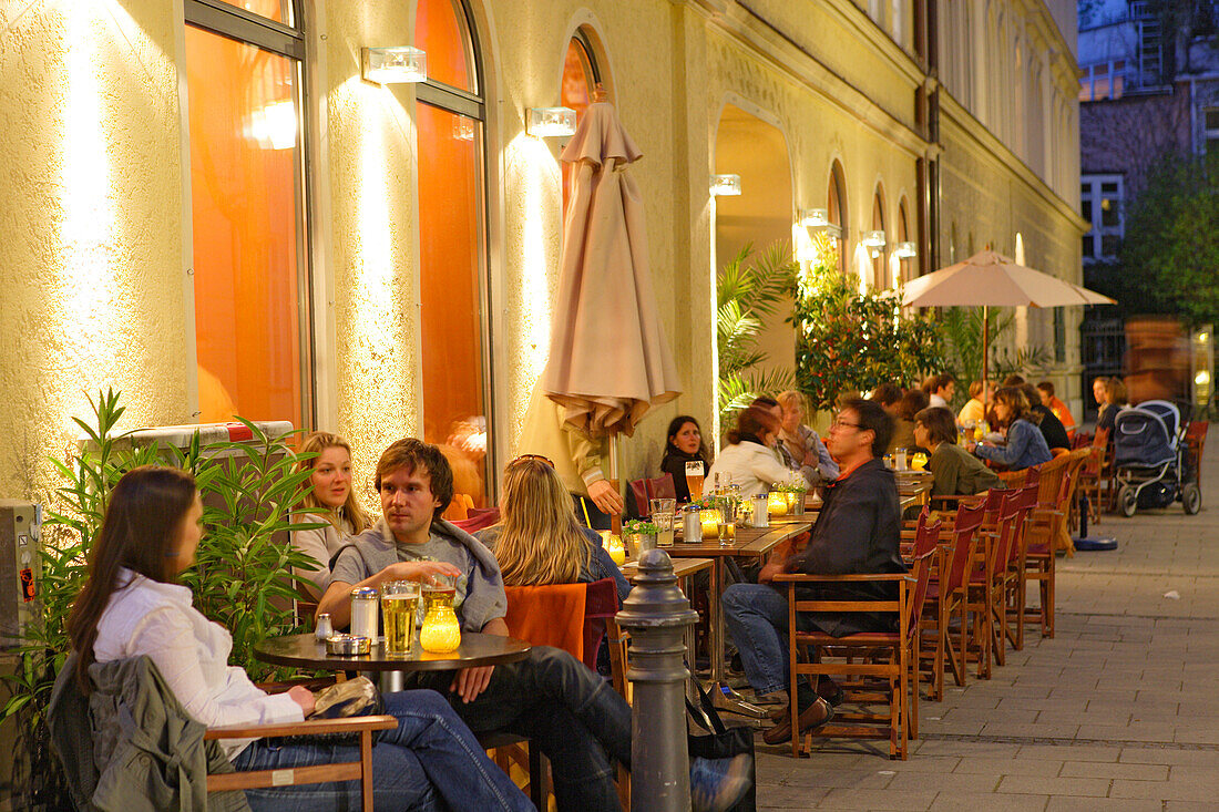 People sitting in front of Cafe Zeitgeist in the evening, Maxvorstadt, Munich, Bavaria, Germany