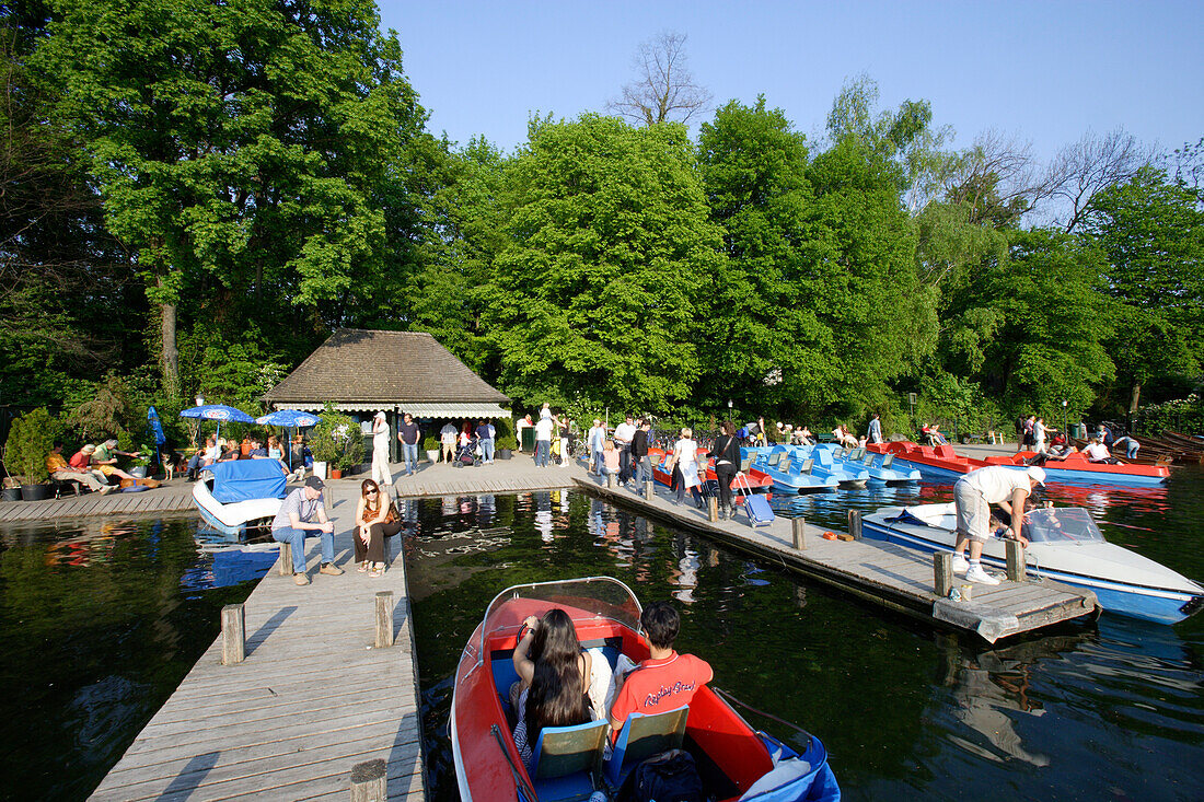 Menschen fahren mit Booten, Bootsverleih am Kleinhesseloher See, Englischer Garten, Schwabing, München, Bayern, Deutschland