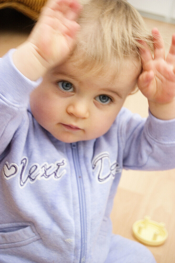 10 month old baby arms in the air, big blue eyes