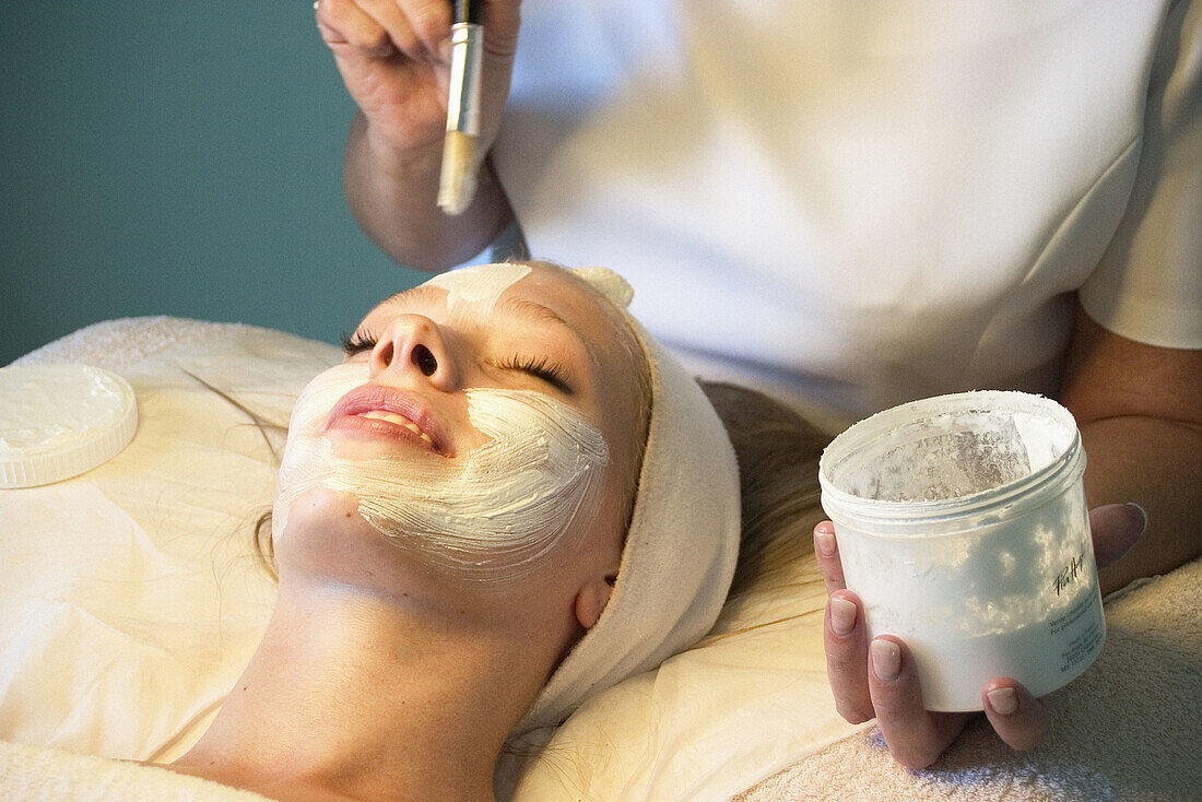 21 year old woman having a face mask applyed by a beauty therapist