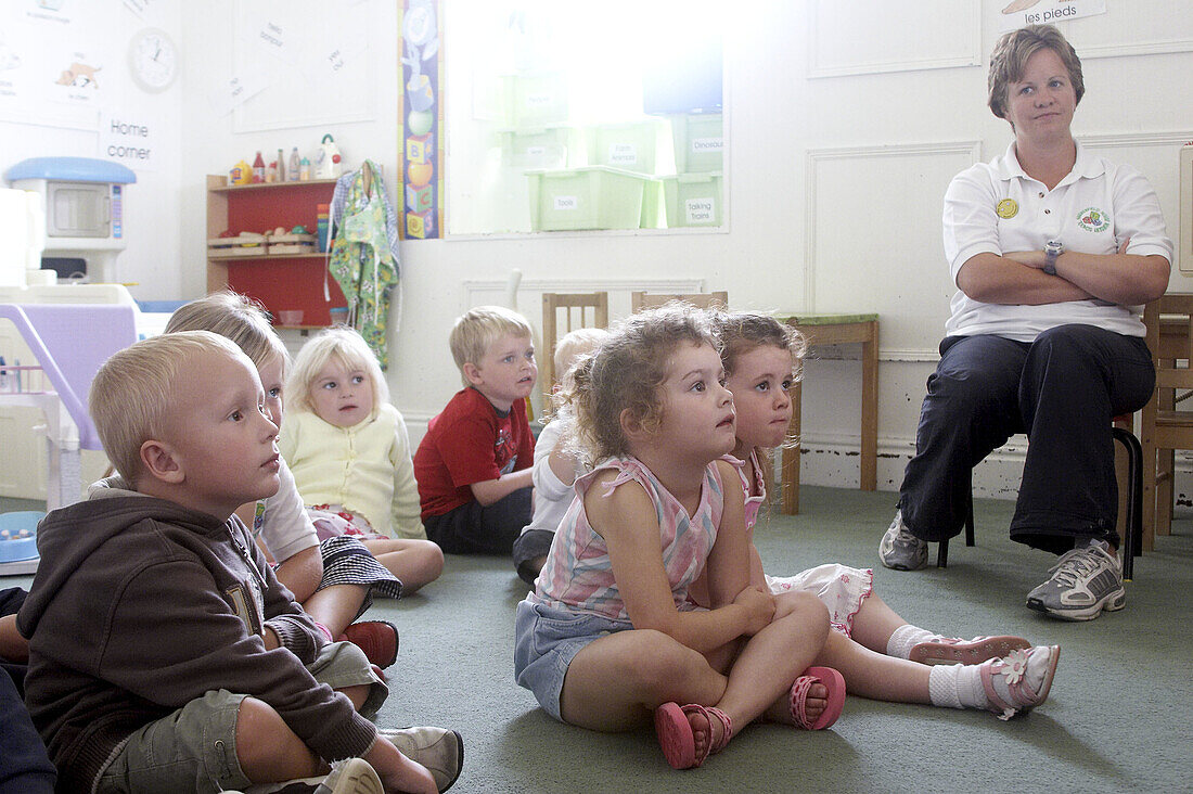 group of 2-4 year old children sitting in the classroom with the teacher