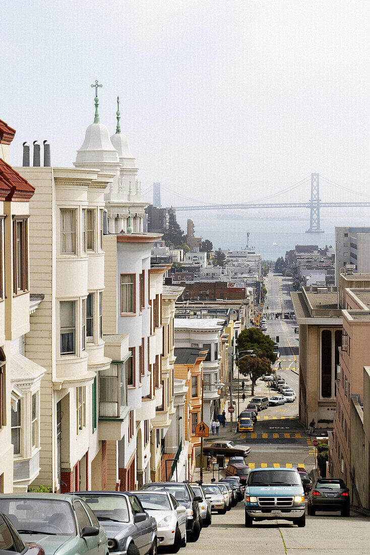 Steep, hilly street, Oakland Bay Bridge in distance. San Francisco. California, USA