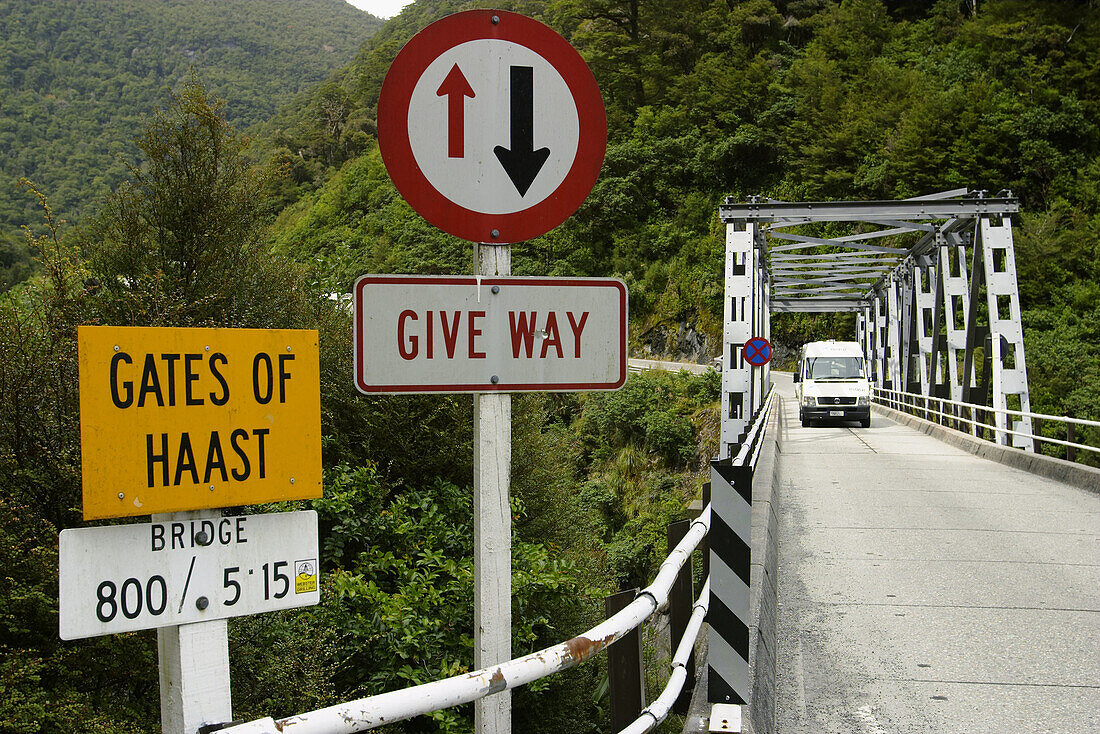 Caravan on one-lane bridge over Gates of Haast, right of way sign, yield . Haast Pass. New Zealand