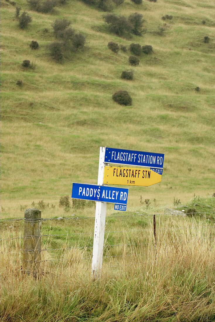 Signpost along road, blue and yellow arrows point directions. Atholl. New Zealand