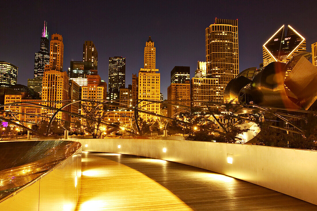 BP Amoco Bridge in Millennium Park at night, Chicago city skyline