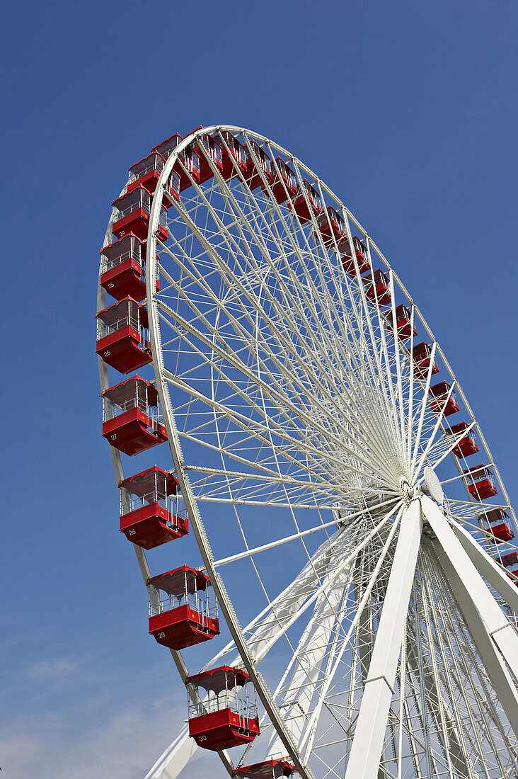 LAKEFRONT. Chicago, Illinois. Navy Pier, popular tourist destination, Ferris wheel against blue sky, white with red gondola cars