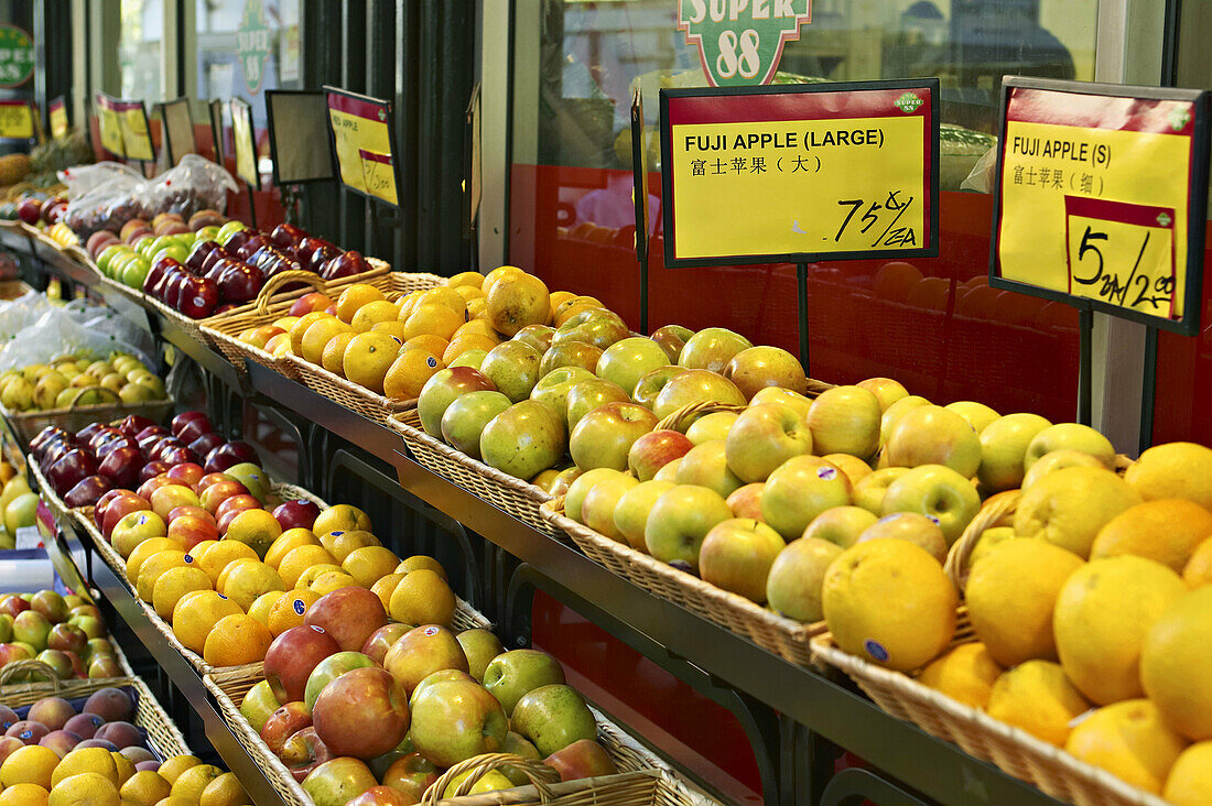 Massachusetts, Boston, Chinatown district in city, fruit displayed in baskets on shelves, outside grocery store, signs in English and Chinese