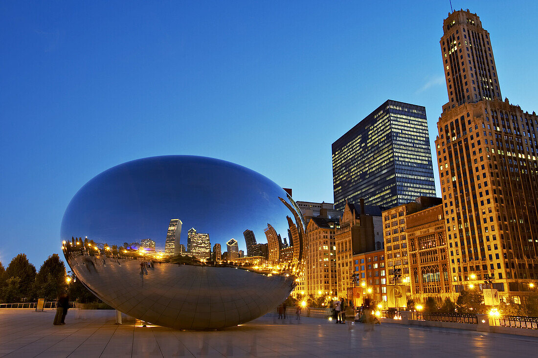 Parks. Popular Bean sculpture in Millennium Park, city reflected in stainless steel on kidney bean shape, Cloud Gate at dusk. Chicago. Illinois, USA