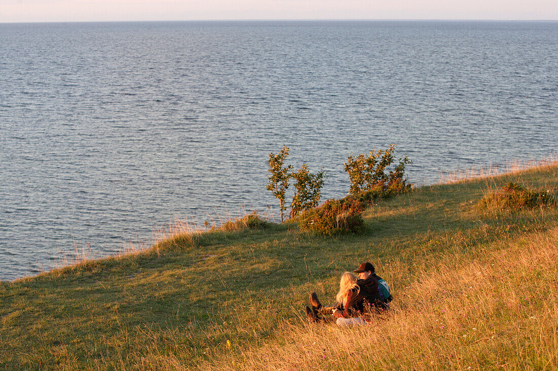 A couple sitting on a cliff at the Northern coast, Panga Pank, island Saaremaa, Estonia